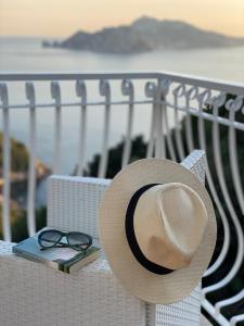 a hat and a book and glasses on a chair at Acquamarina Accommodation in Massa Lubrense