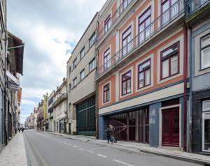 a person walking down a street in a city at Uma Formosa Apartments in Porto