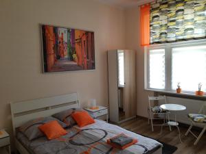 1 dormitorio con 1 cama con almohadas de color naranja en noclegi przy dworcu PKP en Breslavia