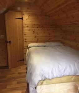 sypialnia z łóżkiem w drewnianej ścianie w obiekcie Lodge w mieście Yeovil