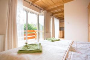 1 dormitorio con 1 cama y 2 toallas verdes en Willa u Bohuna, en Zakopane