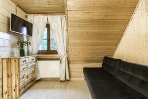 een woonkamer met een bank en een raam bij Willa Franciszek in Zakopane
