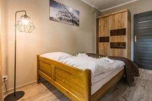 a bedroom with a bed with a lamp and a door at Apartamenty Izerskie - ul. Sienkiewicza 9 in Świeradów-Zdrój