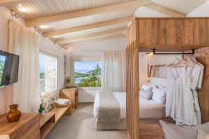 a bedroom with a canopy bed and a large window at Sivota's Secret Villa in Sivota