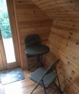 une petite cabine avec deux chaises et un tabouret dans l'établissement Lodge, à Yeovil