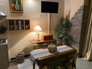 a kitchen with a table with a lamp and a television at Residenza Il Rustico Lago Maggiore in Gravellona Toce