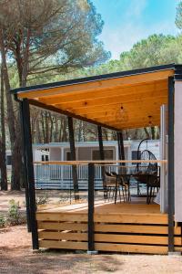 einen hölzernen Pavillon mit einem Tisch und Stühlen in der Unterkunft Lux camp - mobile homes in Bi village in Fažana