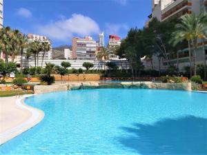 ein großer blauer Pool mit einer Stadt im Hintergrund in der Unterkunft Gemelos 22-3-12 in Benidorm