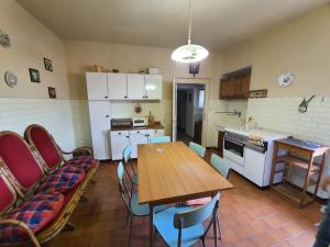a kitchen with a wooden table and a table and chairs at Apartment zeus Lizzano in Veccialone +7 photos