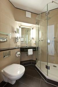 a bathroom with a toilet and a glass shower at Hotel Für Dich in Waren