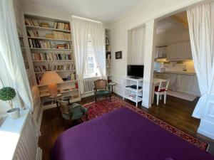 a living room with a purple bed and a desk at Les Lumières de la ville in Strasbourg