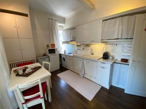 史特拉斯堡的住宿－Les Lumières de la ville，厨房配有白色橱柜、桌子和柜台。