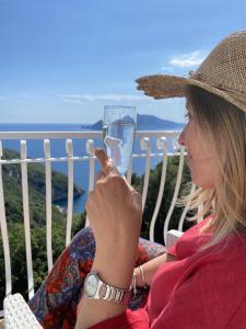 a woman is holding a glass of wine at Acquamarina Accommodation in Massa Lubrense