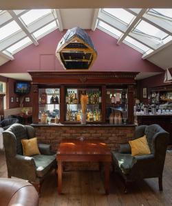 een bar met 2 stoelen en een tafel bij Innishannon House Hotel in Inishannon