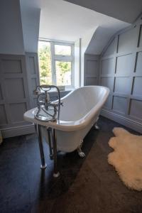 a white bath tub in a room with a window at Innishannon House Hotel in Inishannon