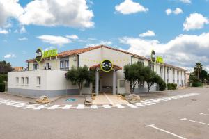 een hotel met een bord aan de zijkant van een parkeerplaats bij B&B HOTEL Narbonne 2 in Narbonne