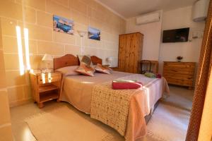 Schlafzimmer mit einem Bett mit einem Tisch und einem Spiegel in der Unterkunft Sunset Seaview Accommodation in Marsalforn