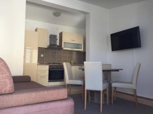 a living room with a kitchen and a table and chairs at Petros Apartments Pag in Pag