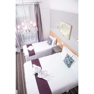 プリマスにあるThe Retreat Guest House on Plymouth Hoeのベッド2台とシャンデリアが備わる客室です。