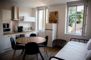 eine Küche mit Tisch und Stühlen in einem Zimmer in der Unterkunft ALBIAPPART VIGAN centre ville in Albi