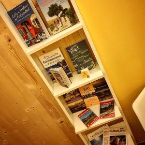 a book shelf filled with books on a wall at Pension Maria in Antdorf