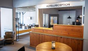 eine Hotellobby mit einer Rezeption und einem Tisch in der Unterkunft Bergshotellet in Järvsö