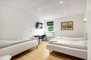 a white room with two beds and a desk at Gørding Bed and Breakfast in Gørding