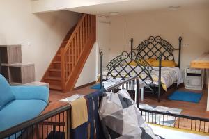 um quarto com uma cama e um sofá azul e escadas em Gazelle Guest House and Art Gallery em Ruffec