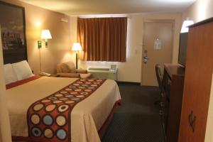a hotel room with a large bed and a television at Super 8 by Wyndham Laurel in Laurel