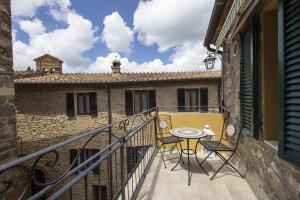 a balcony with a table and chairs on a building at La Togata Hotellerie de Charme Relais il Terrazzo in Montalcino