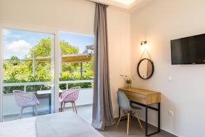 La Maison Corfu - Adults Only في إيبسوس: غرفة نوم بسرير ومكتب ونافذة