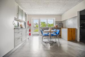 a kitchen with a table and blue chairs at Gørding Bed and Breakfast in Gørding