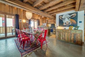 ヴァル・ディゼールにあるMadame Vacances Le Chalet Denaliのダイニングルーム(テーブル、赤い椅子付)