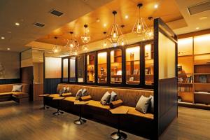 a restaurant with couches and chandeliers at JR Inn Hakodate in Hakodate