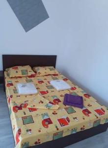 a bed with a yellow comforter with at Beta Residence Saturn in Mangalia