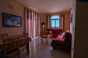 ein Wohnzimmer mit einem Sofa und einem Tisch in der Unterkunft Sunset Seaview Accommodation in Marsalforn