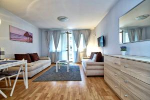 ein Wohnzimmer mit einem Sofa und einem Tisch in der Unterkunft Apartament Park Zdrojowy 2 in Świnoujście