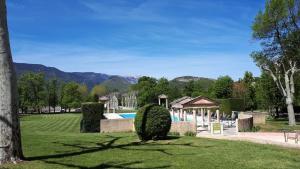 a garden with a swimming pool and a house at Appartement 7 Château des Gipières in Montbrun-les-Bains