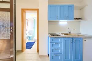 cocina azul con fregadero y baño en Apartman ANTICA, en Vantačići