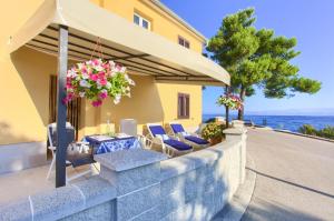 a patio with a table and chairs and an umbrella at Apartman ANTICA in Vantačići
