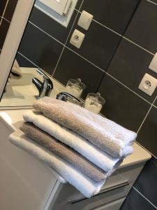 a pile of towels sitting on a counter in a bathroom at Les gîtes de Joséphine in Courbouzon