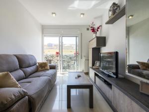 a living room with a couch and a tv at POSEIDÓN Bonito y cuidado apartamento con wifi gratis in Pineda de Mar