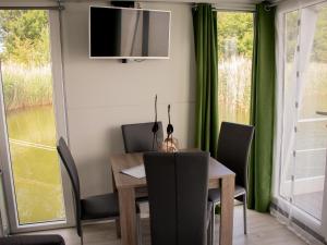 een eetkamer met een tafel en stoelen en een tv bij Houseboat uitzicht over veluwemeer, natuurlokatie, prachtige vergezichten in Biddinghuizen