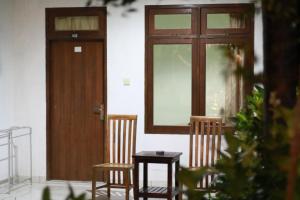 dos sillas y una mesa frente a una puerta en Medori Putih Homestay, en Uluwatu