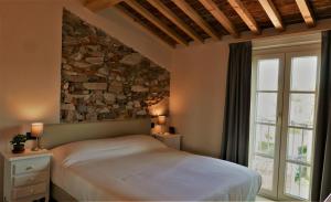 a bedroom with a bed and a stone wall at Il Tiglio Jacuzzi&Sauna in Lucca