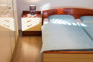 a bedroom with a bed and a dresser with a lamp at Apartman ANTICA in Vantačići