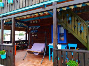 a porch with a chair and a table and stairs at Casa Toth in Vişeu de Sus