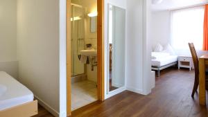 a room with a bathroom with a bed and a sink at Hotel Frieden in Davos