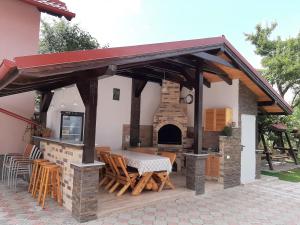 un patio con una mesa y un horno de pizza en Vila Nicolai en Cristian
