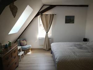 a bedroom with a bed and a window at chez Coco in Riquewihr